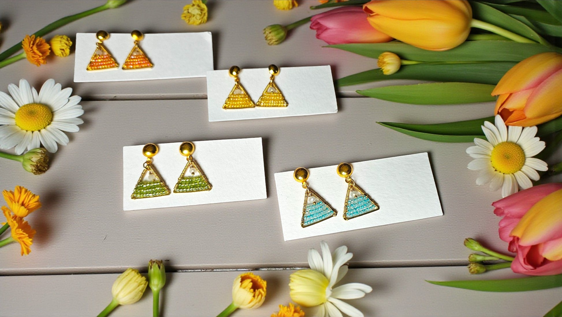 Anushka - beaded wire wrap earrings | Handmade earrings displayed with colorful flowers.