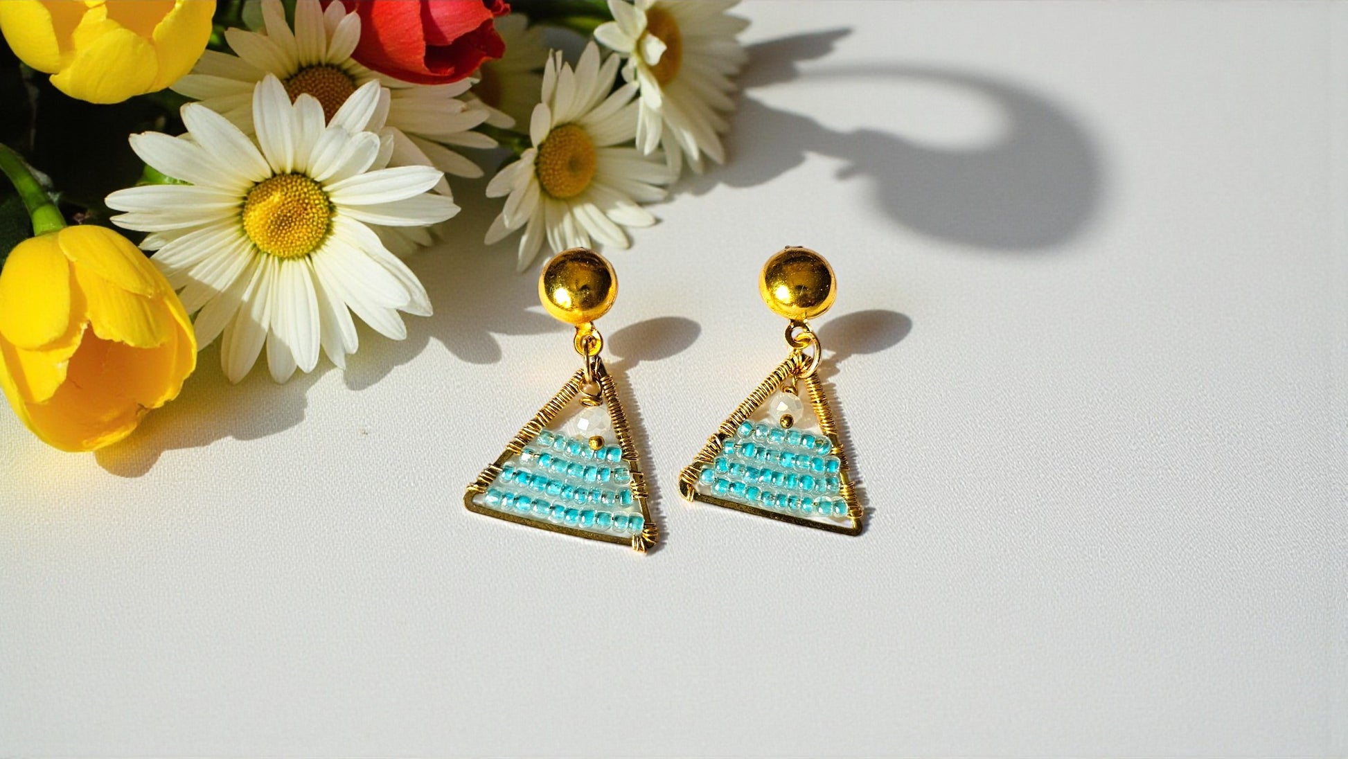 Anushka - beaded wire wrap earrings | Handmade earrings featuring a triangular design with blue beads and gold accents