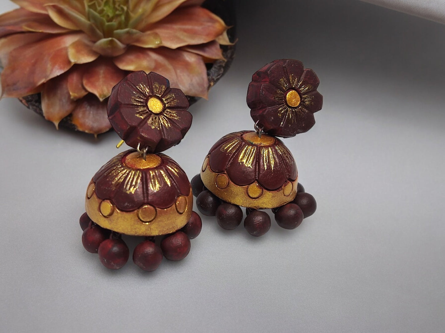 Anusangi Collections brown flower jhumka terracotta earrings with intricate floral design and bead detailing