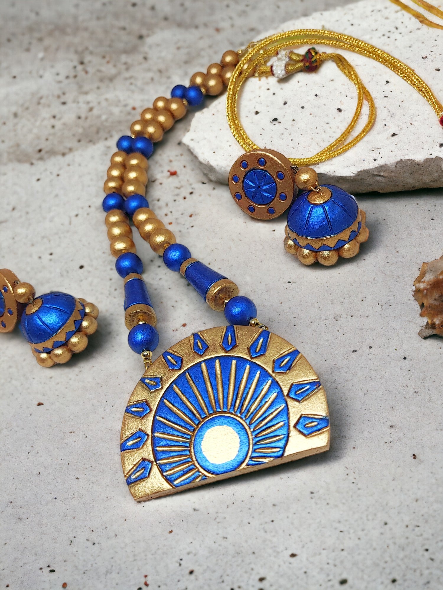 Dark blue terracotta jewelry set with gold accents including necklace and earrings from Anusangi Collections