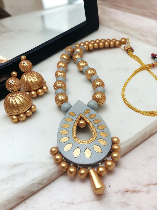Anusangi Collections gold and gray jewelry set terracotta necklace and matching earrings on marble surface