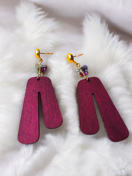 Purple wooden earrings with gold studs and decorative beads by Anusangi Collections on white fur background