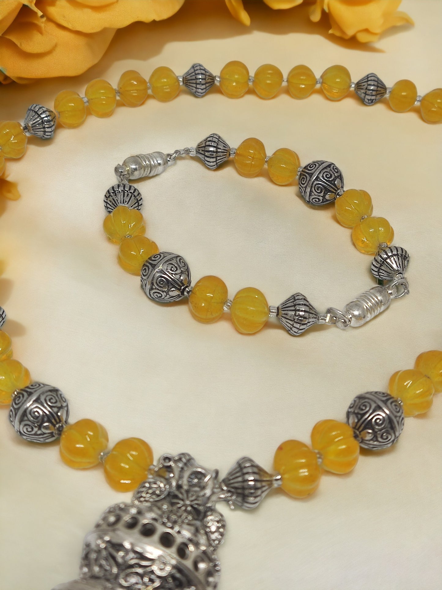 Handmade beaded jewelry set with yellow beads and intricate silver charms from Anusangi Collections