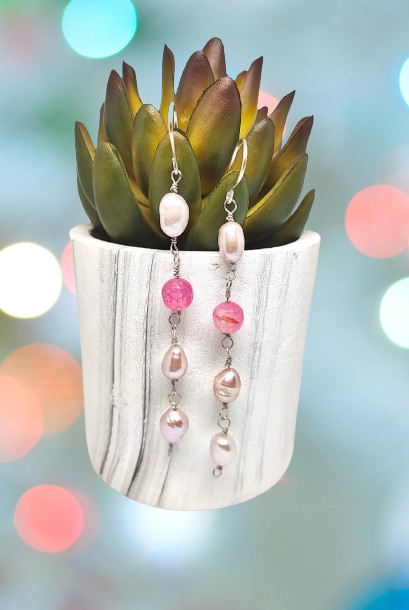 Handmade sterling silver earrings with pink pearls and beads displayed on a small ceramic pot with succulent