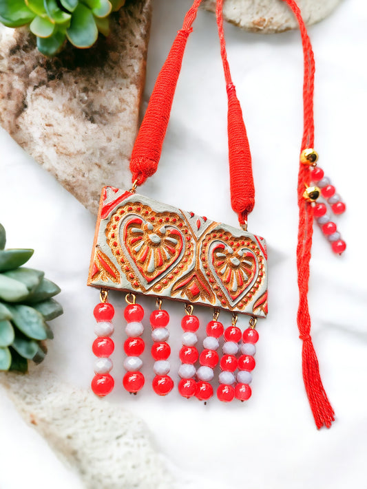 Anusangi Collections heart motif terracotta jewelry set with red and white beads and intricate design