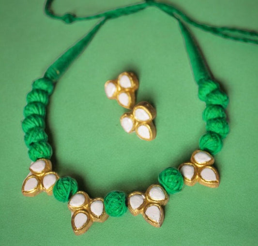 Handcrafted from high-quality terracotta, this necklace set features a stunning ivory and green color palette. The carefully sculpted beads and intricate details make it a unique addition to any jewelry collection. Elevate your outfit with this elegant and timeless piece.