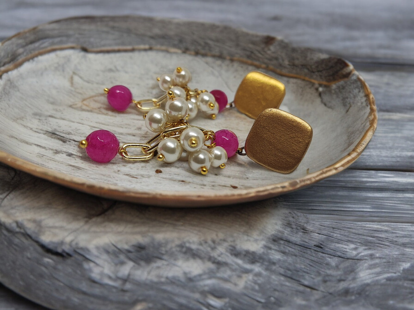 Anusangi Collections ishana terracotta earrings with gold square studs and pink pearl clusters on a wooden plate
