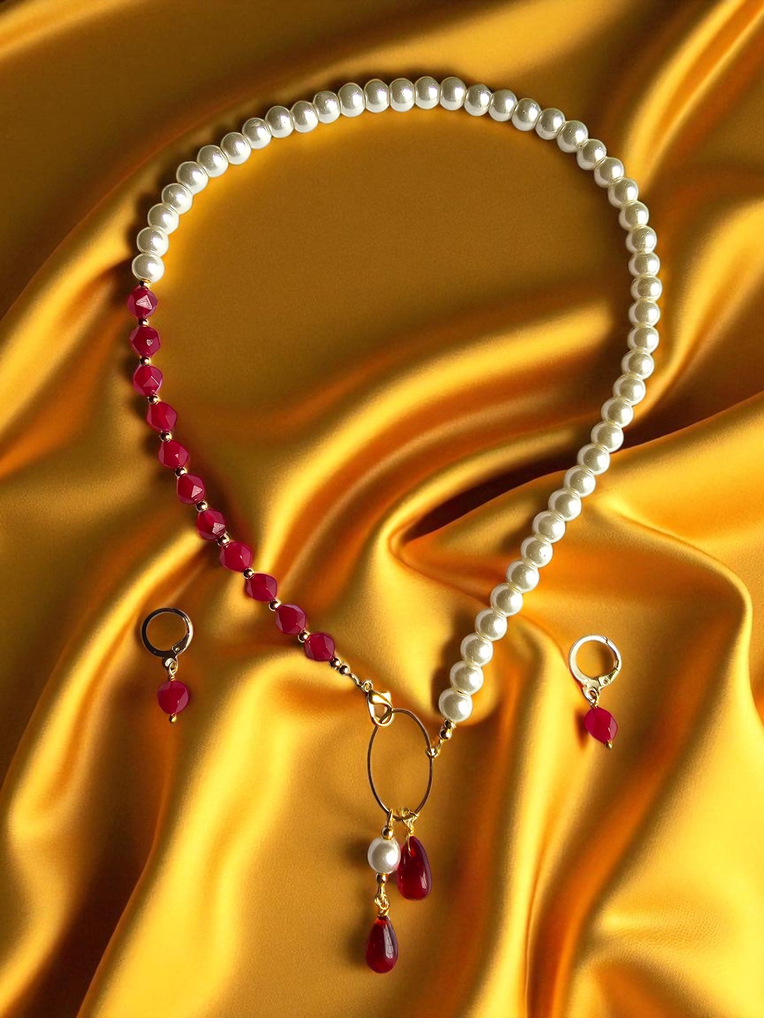 Elegant maroon and pearl jewelry set featuring a necklace and matching earrings against a silky background