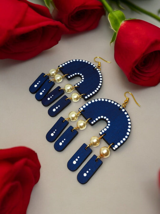 Nila blue statement earrings from Anusangi Collections with beads and pearl accents displayed with red roses
