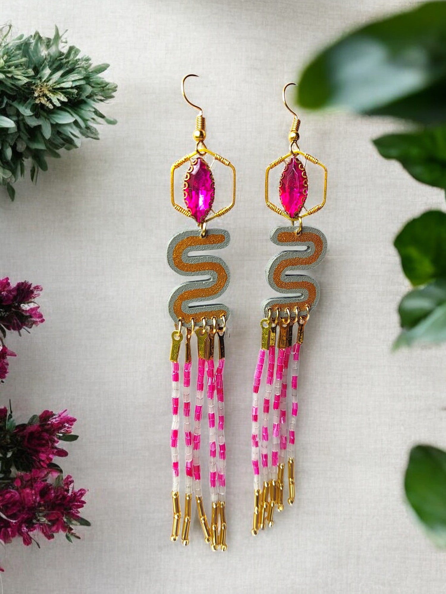 Pink and gold dangle earrings with intricate beading and metal accents from Anusangi Collections