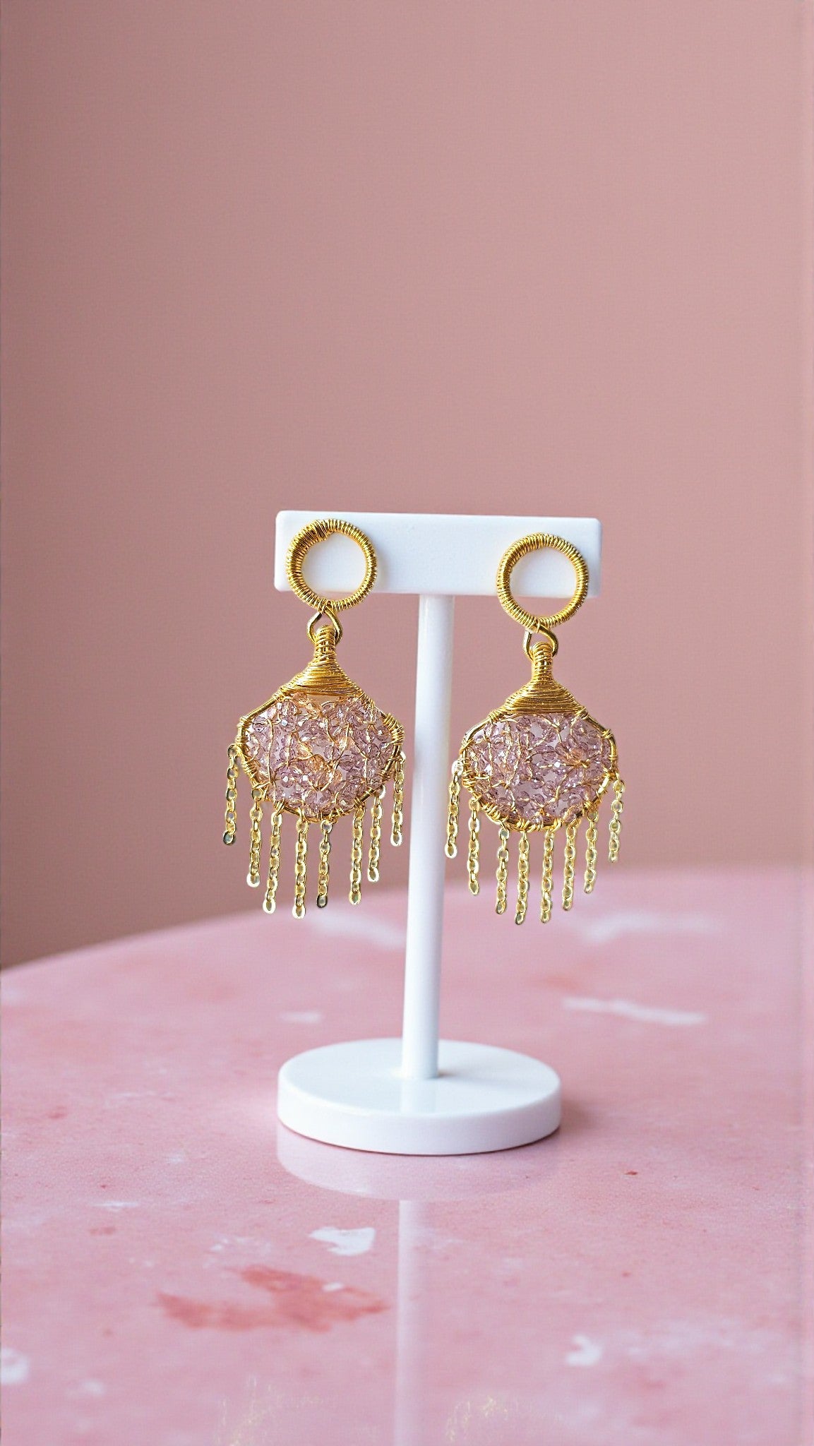Purple Handmade Bead Wrap Earrings featuring intricate designs and gold accents displayed on a white stand