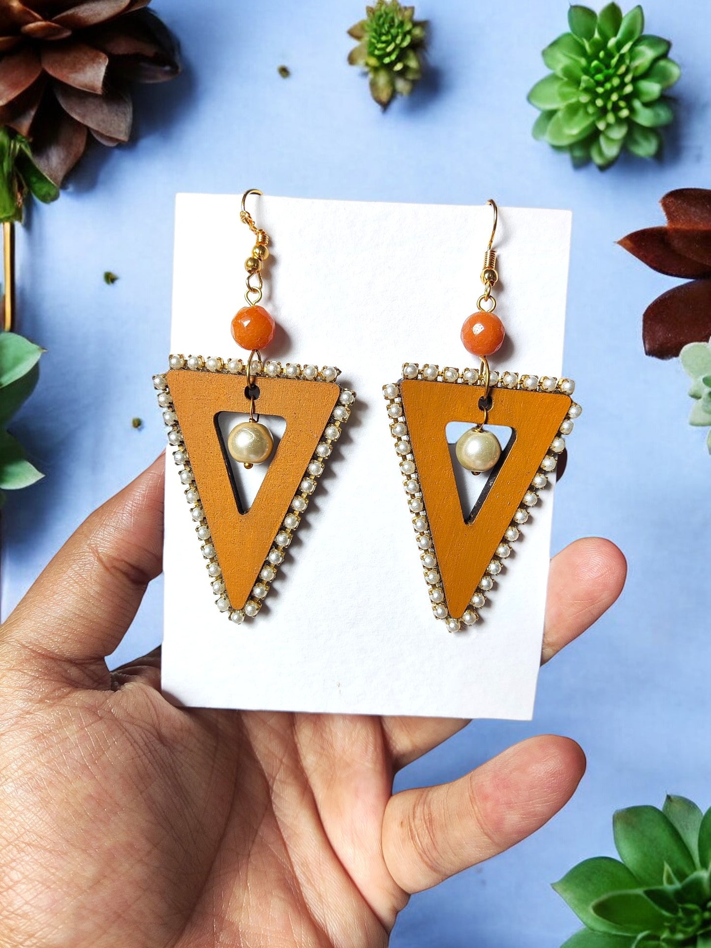 Anusangi Collections triangle statement earrings beaded with orange and pearl accents held on white card