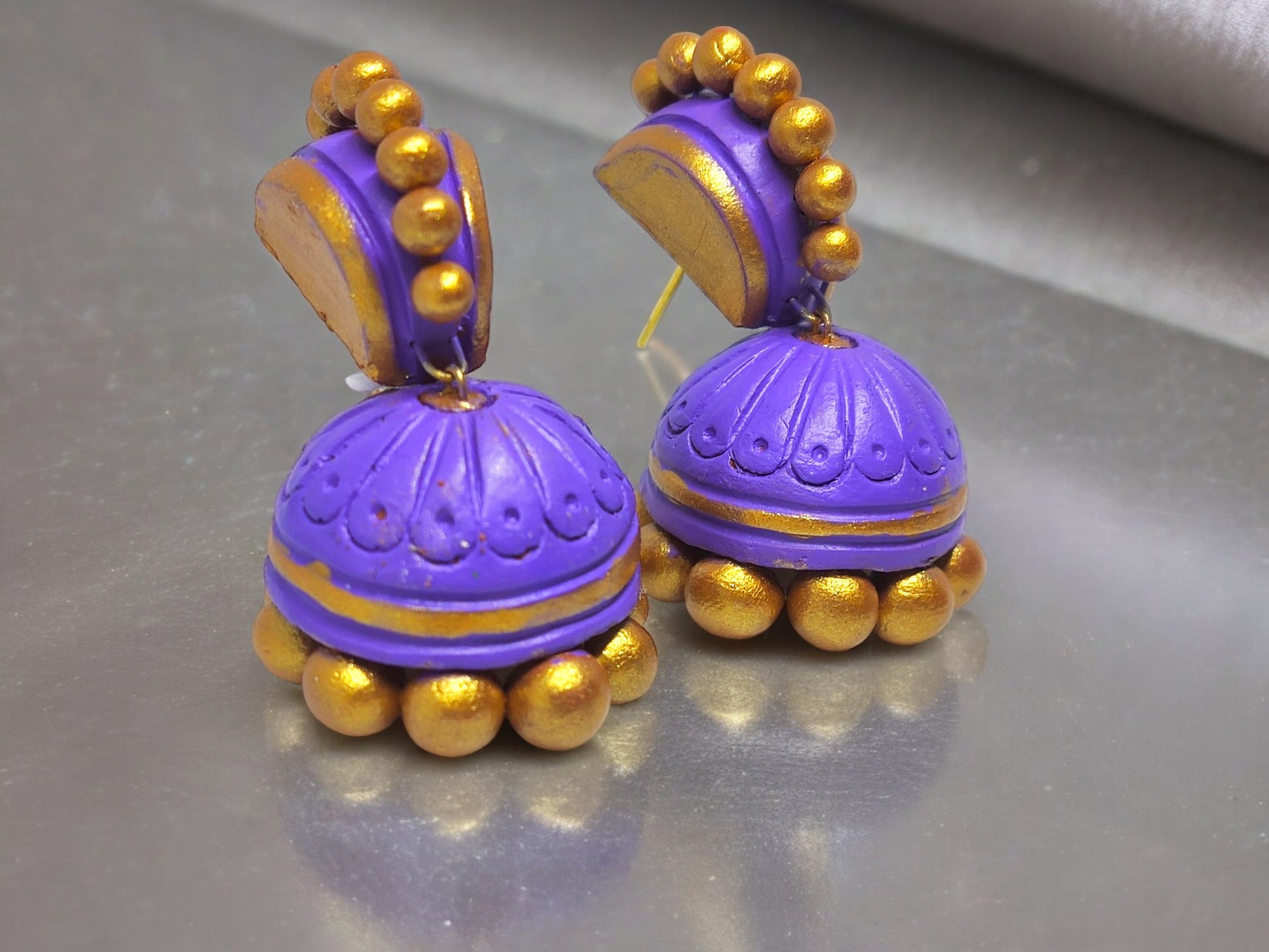 Ethnic purple jhumka earrings made of terracotta with golden bead detailing by Anusangi Collections